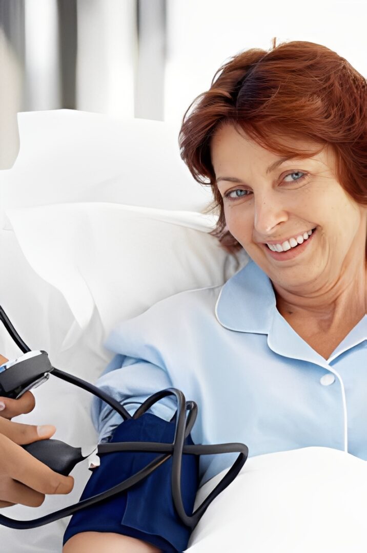 Woman smiling during blood pressure check.