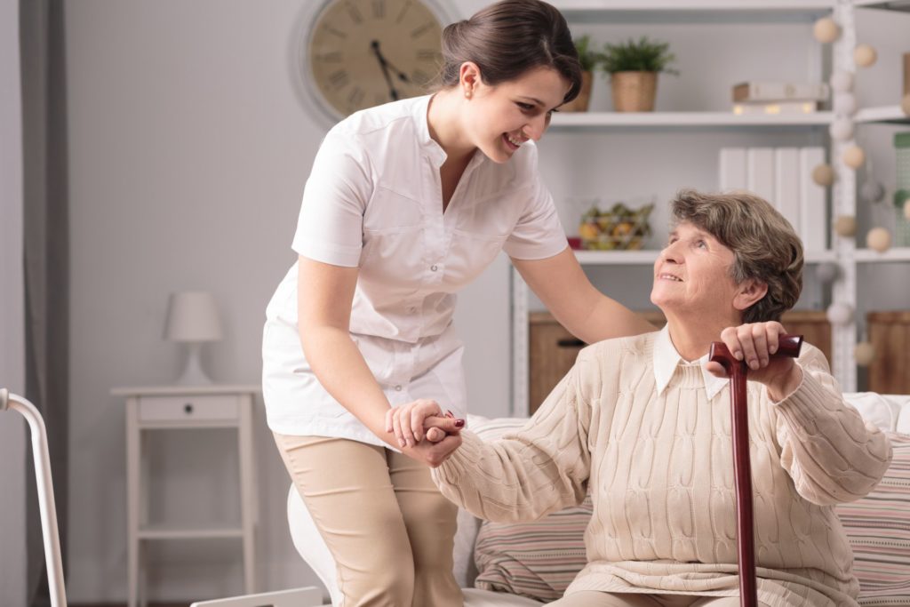 Supportive caregiver with elderly patient smiling